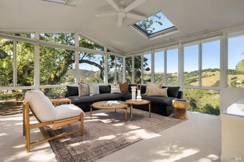 a living room with patio furniture and a floor to ceiling window