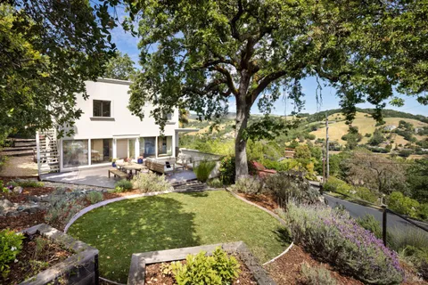 a view of a house with backyard and sitting area