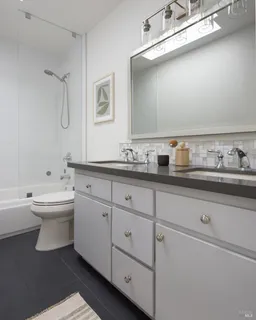 a bathroom with a toilet sink and mirror