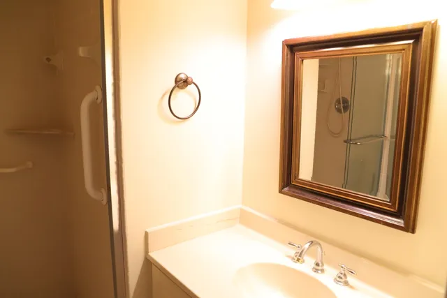 a bathroom with a granite countertop sink and a mirror