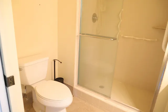 a bathroom with a granite countertop shower and a toilet