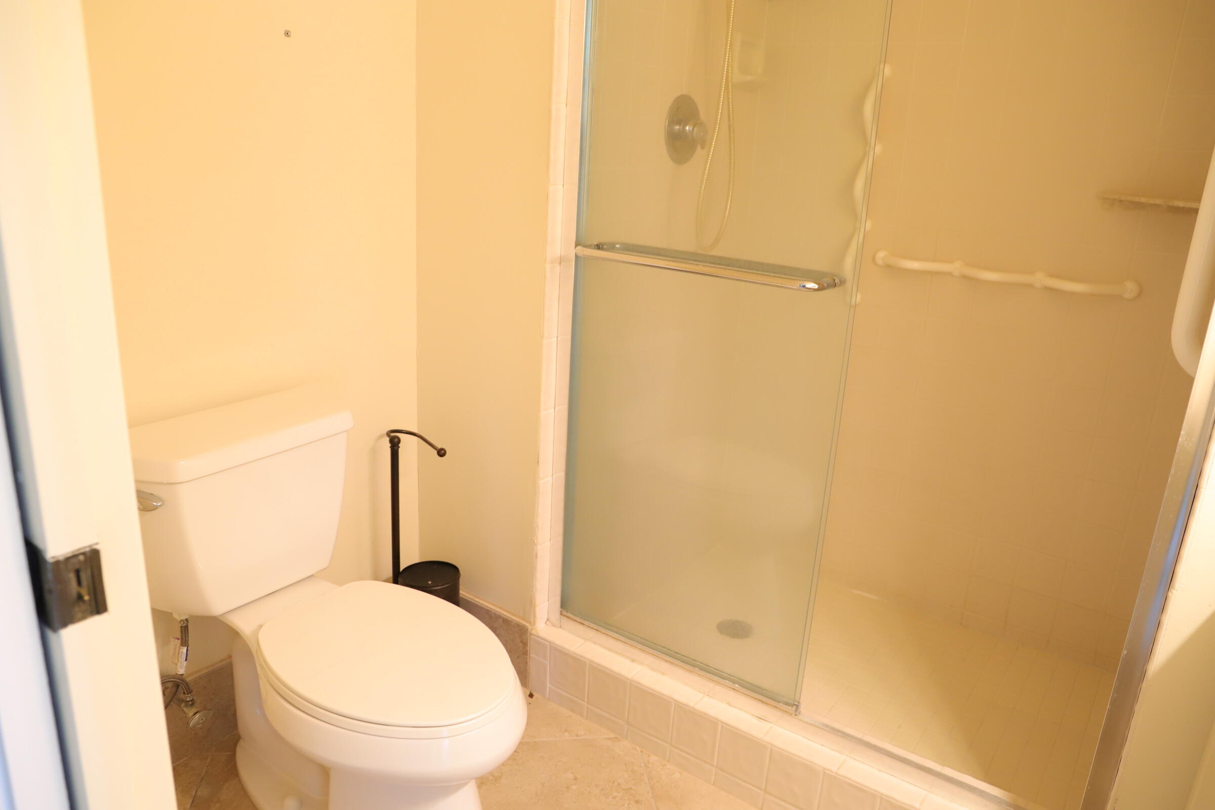 6400 Northwest 2nd Avenue, Unit 423 Boca Raton, FL 33487 - Photo 14 of 19 a bathroom with a granite countertop shower and a toilet