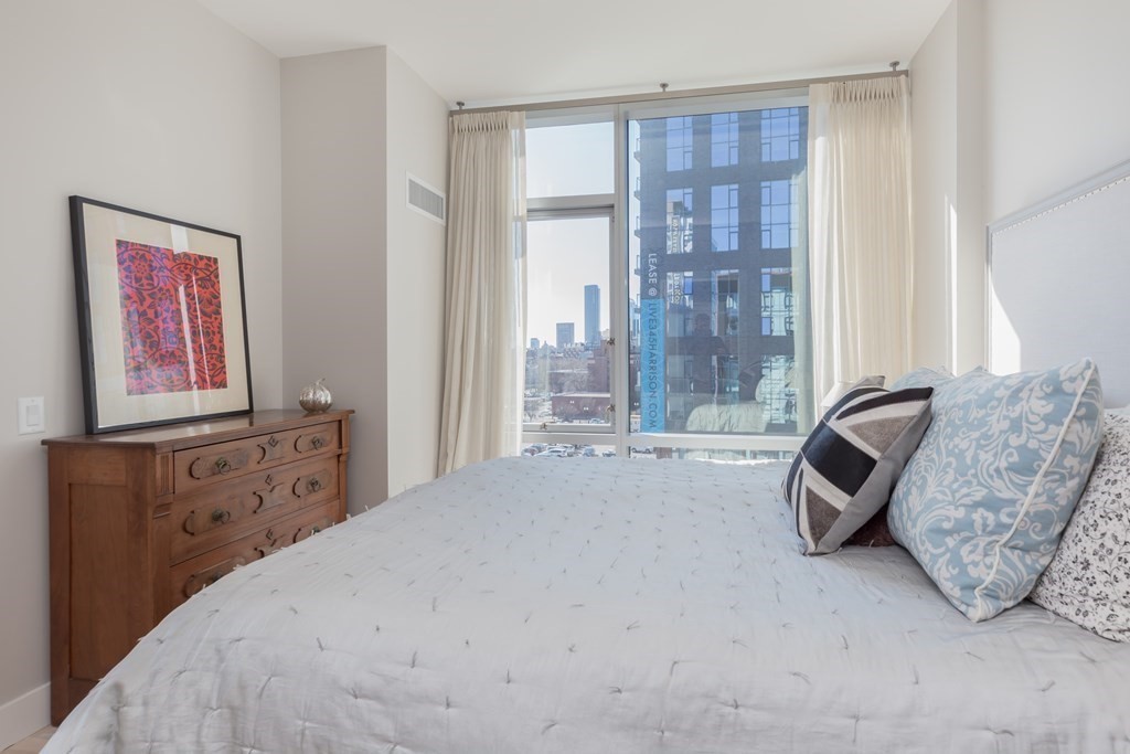 32 Traveler Street, Unit 304 Boston, MA 02118 - Photo 20 of 35 a bedroom with a bed and large windows