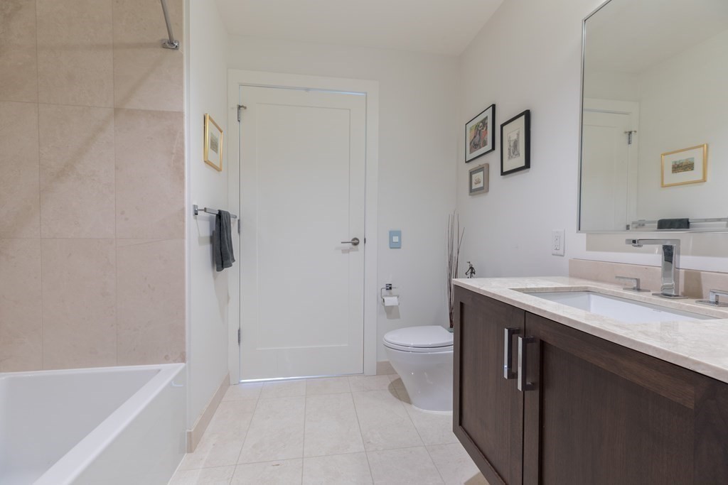 32 Traveler Street, Unit 304 Boston, MA 02118 - Photo 22 of 35 a bathroom with a granite countertop sink a toilet and shower