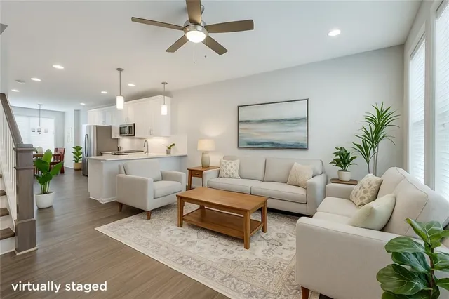 a living room with furniture kitchen view and a potted plant