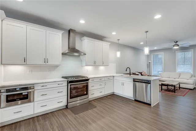 a kitchen with stainless steel appliances a stove top oven and cabinets