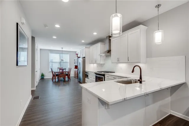 a kitchen with a sink a stove and chairs