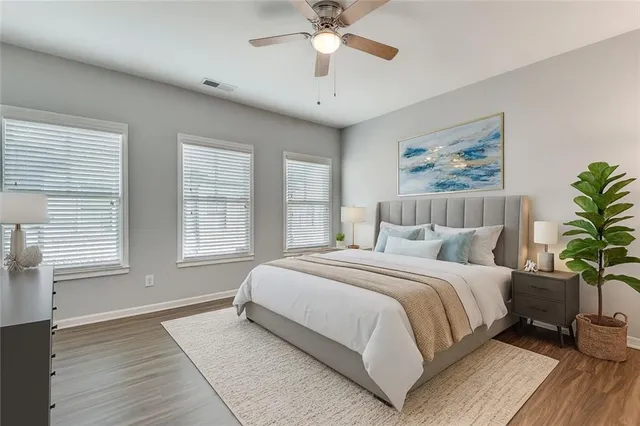 a spacious bedroom with a large bed chandelier and a window