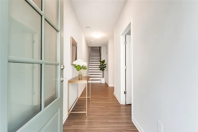 a view of a hallway with wooden floor and staircase