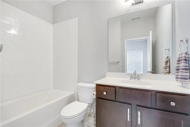 a bathroom with a bathtub shower sink vanity mirror and toilet