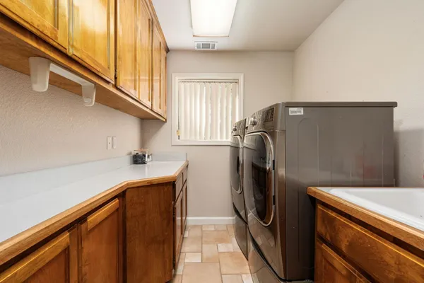 a spacious bathroom with a double vanity sink and mirror with bathtub