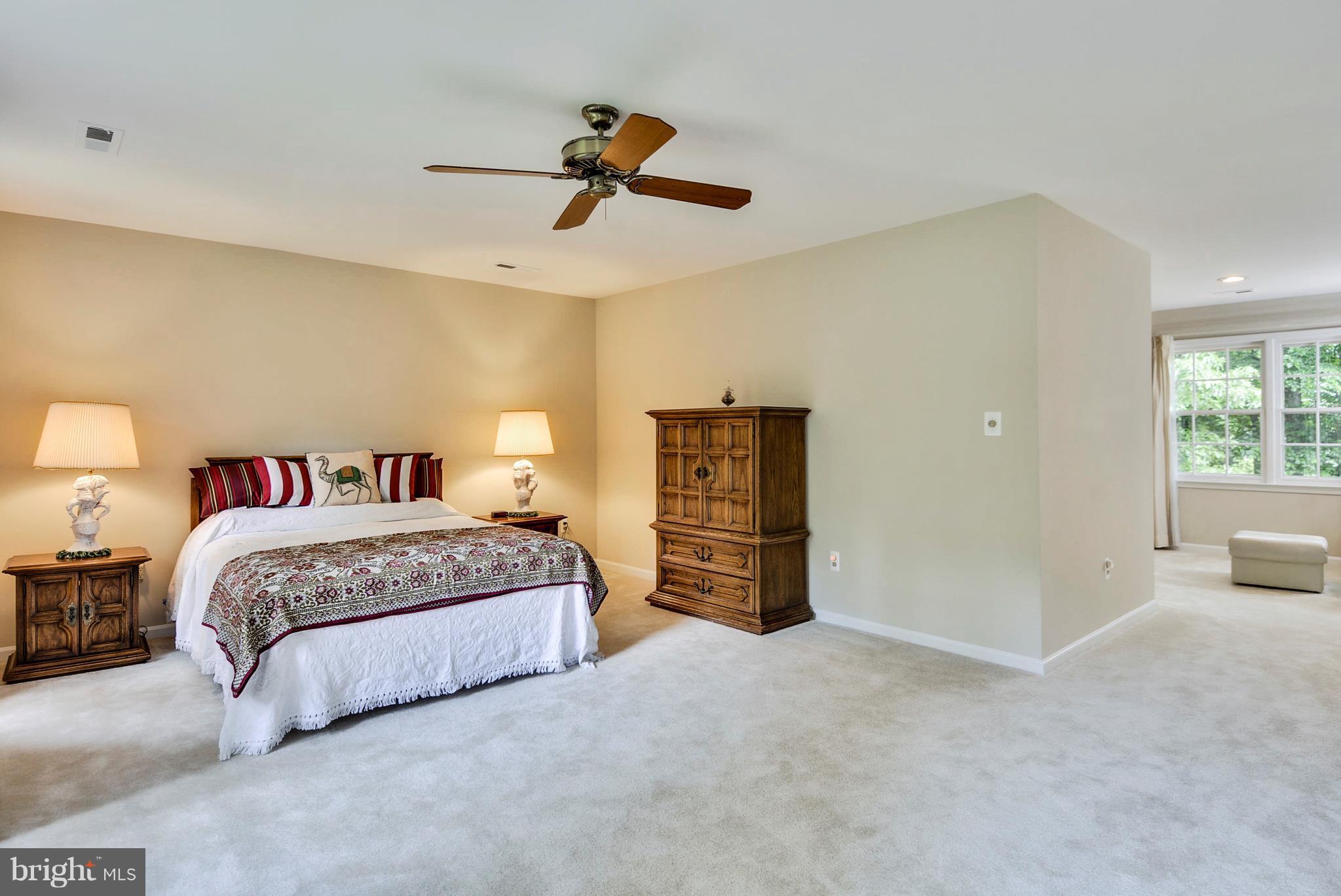 6505 Deidre Terrace McLean, VA 22101 - Photo 13 of 30 a spacious bedroom with a bed and a chandelier