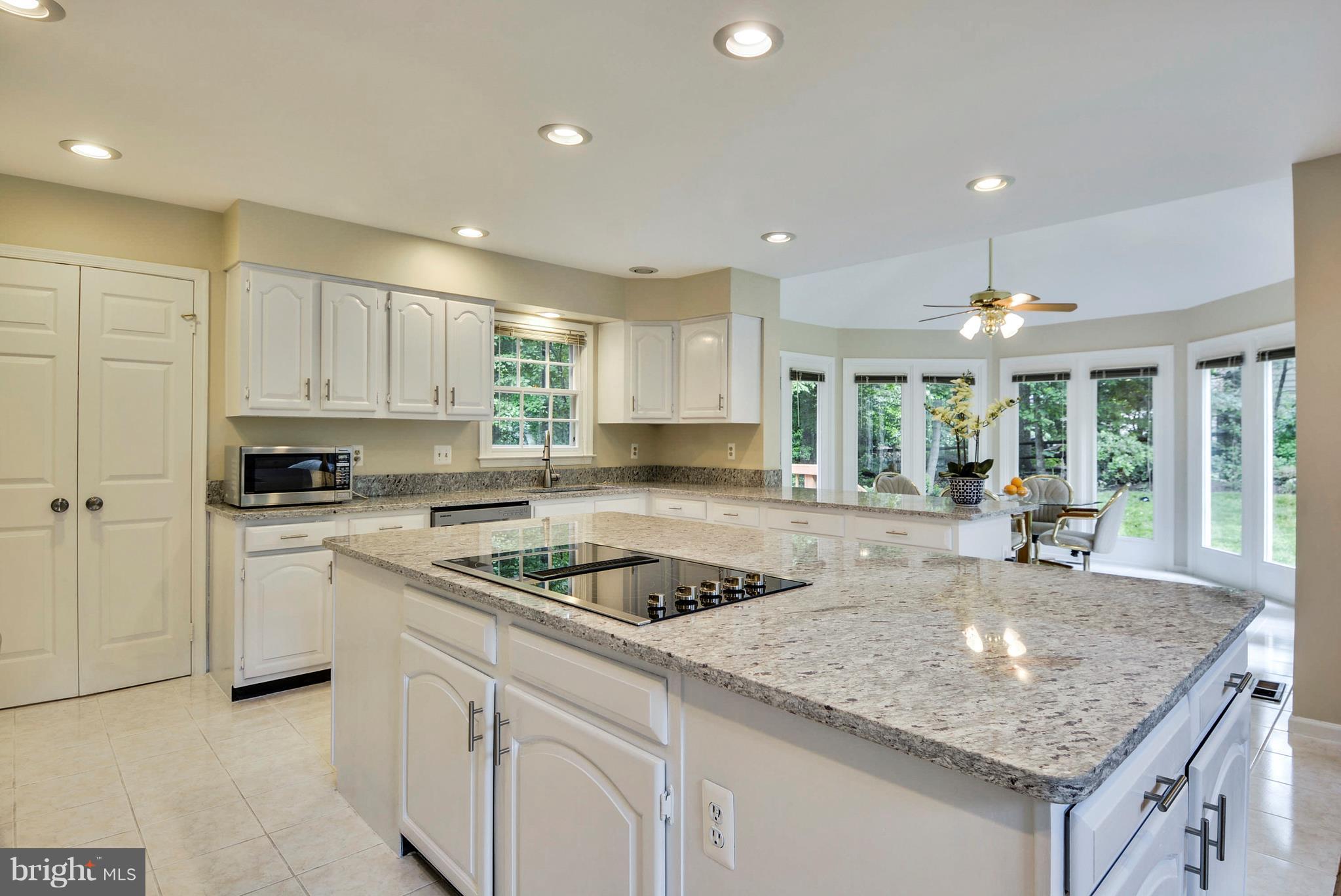 6505 Deidre Terrace McLean, VA 22101 - Photo 7 of 30 a kitchen with granite countertop kitchen island sink stove and white cabinets