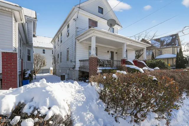 a view of a house with a yard covered in snow