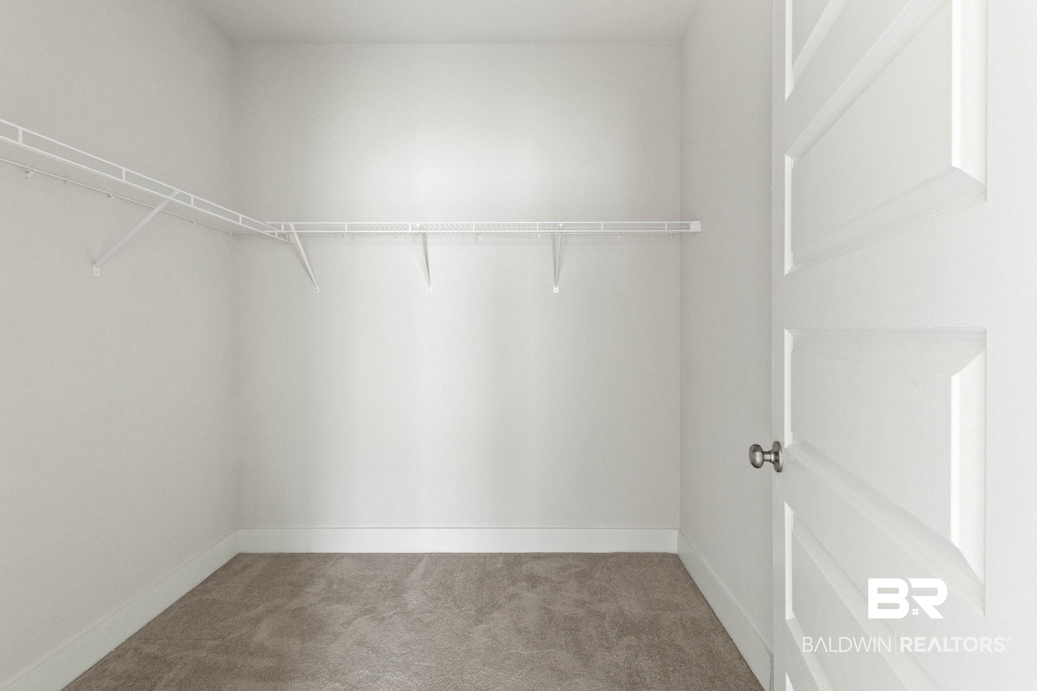 1710 Grouse Street Foley, AL 36535 - Photo 46 of 76 Spacious closet with light gray carpeting, white wire shelving, clean white walls, and a matching paneled door with a brushed nickel knob