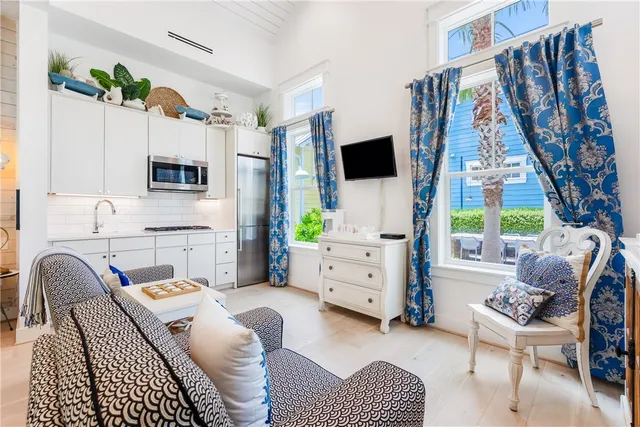 a living room with furniture a flat screen tv and a large window