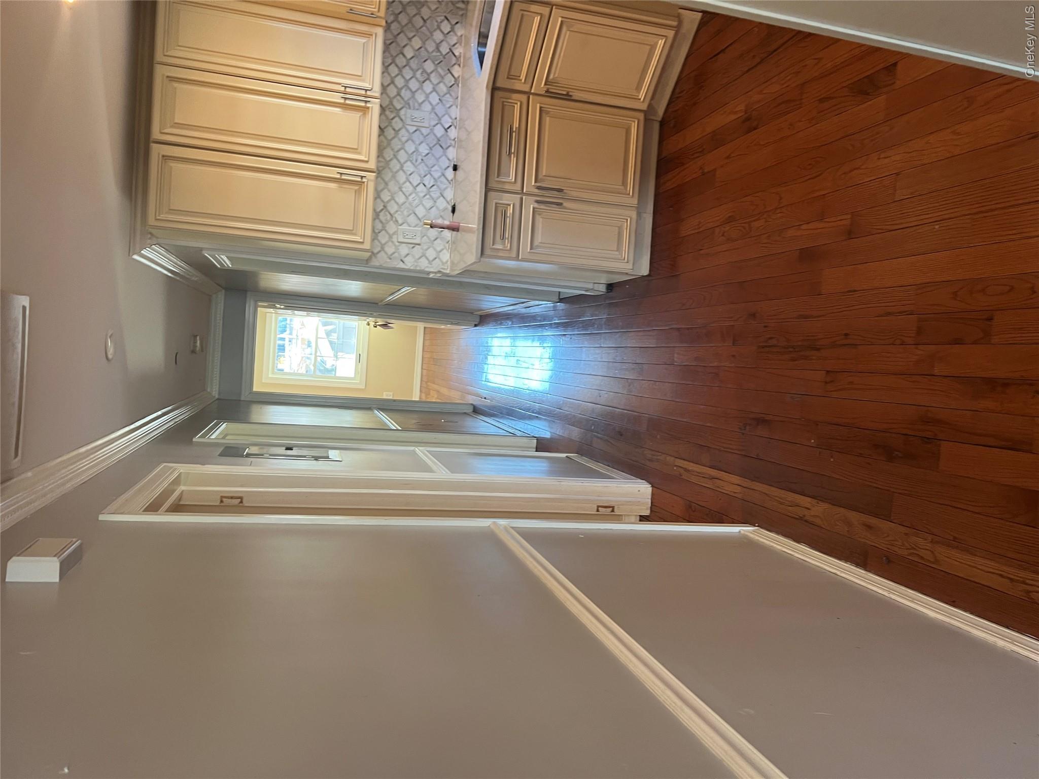 189-20 117th Road Queens, NY 11412 - Photo 12 of 26 wooden floor in an empty room with a window