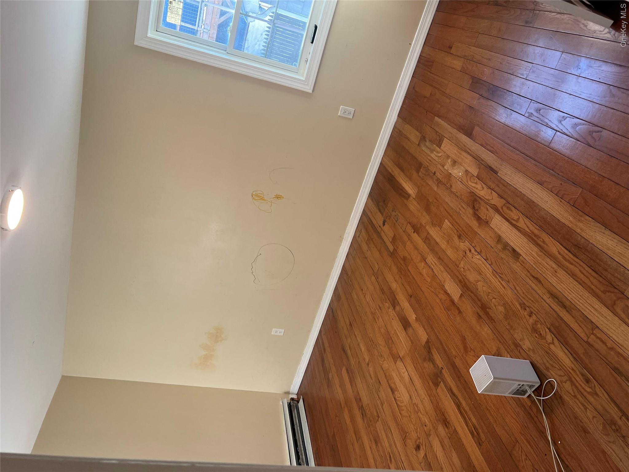 189-20 117th Road Queens, NY 11412 - Photo 13 of 26 a view of an empty room with wooden floor and a window