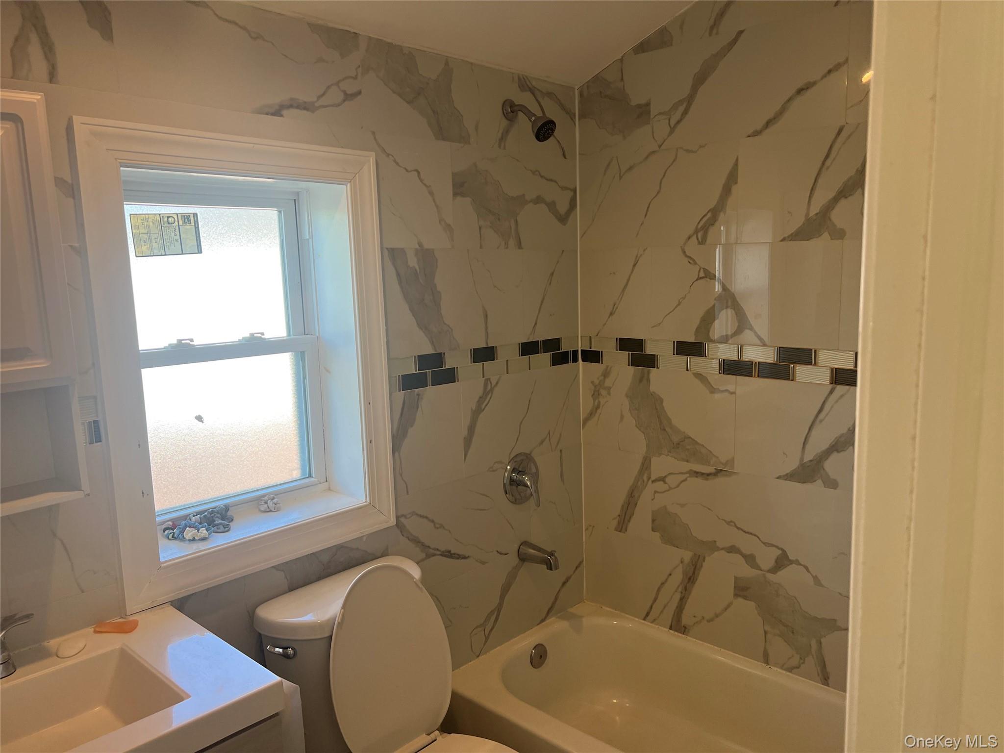 189-20 117th Road Queens, NY 11412 - Photo 24 of 26 a bathroom with a tub a sink and a window