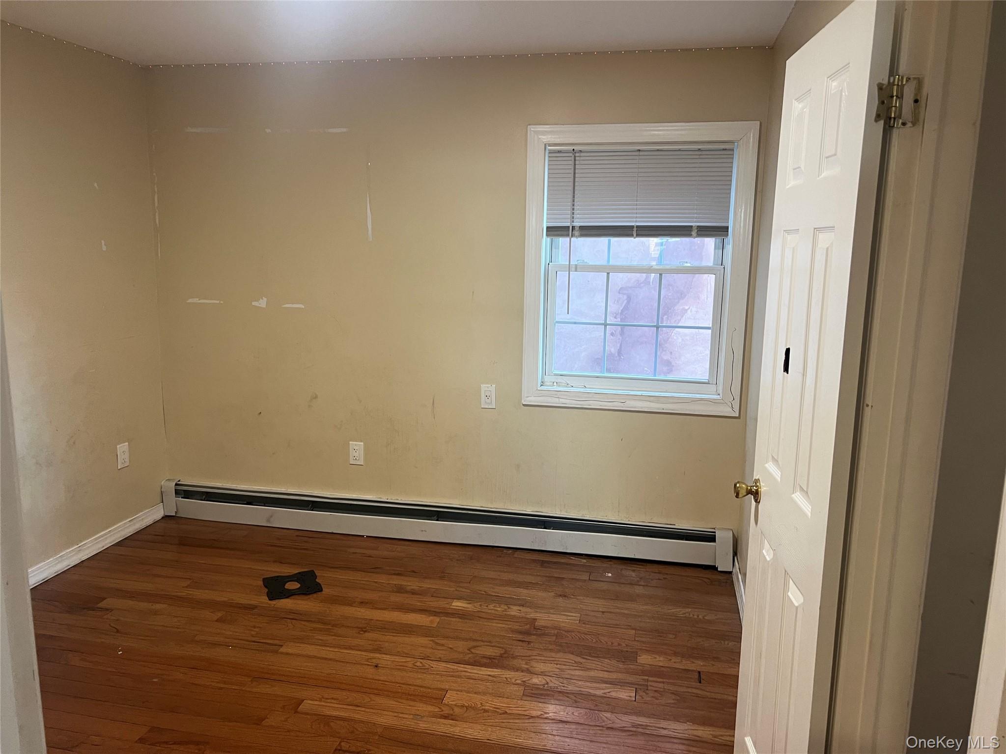 189-20 117th Road Queens, NY 11412 - Photo 9 of 26 a view of a room with wooden floor and small window
