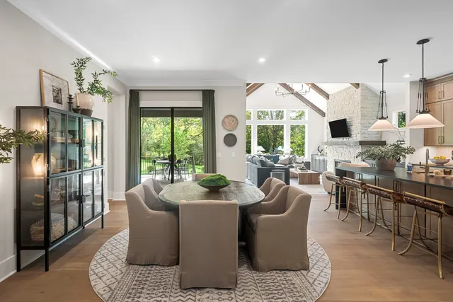 a kitchen with stainless steel appliances granite countertop a table chairs stove and refrigerator