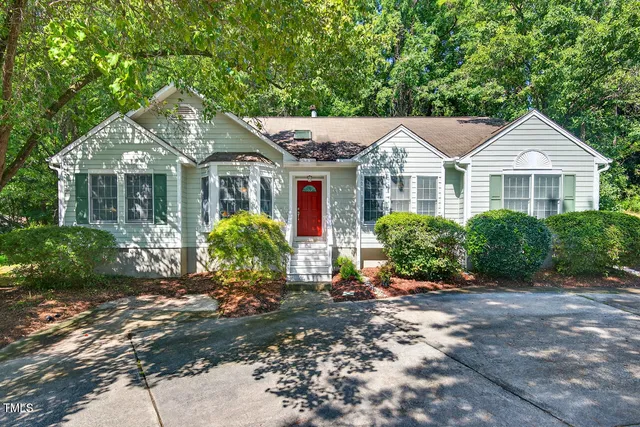 a front view of a house with a yard and potted plants