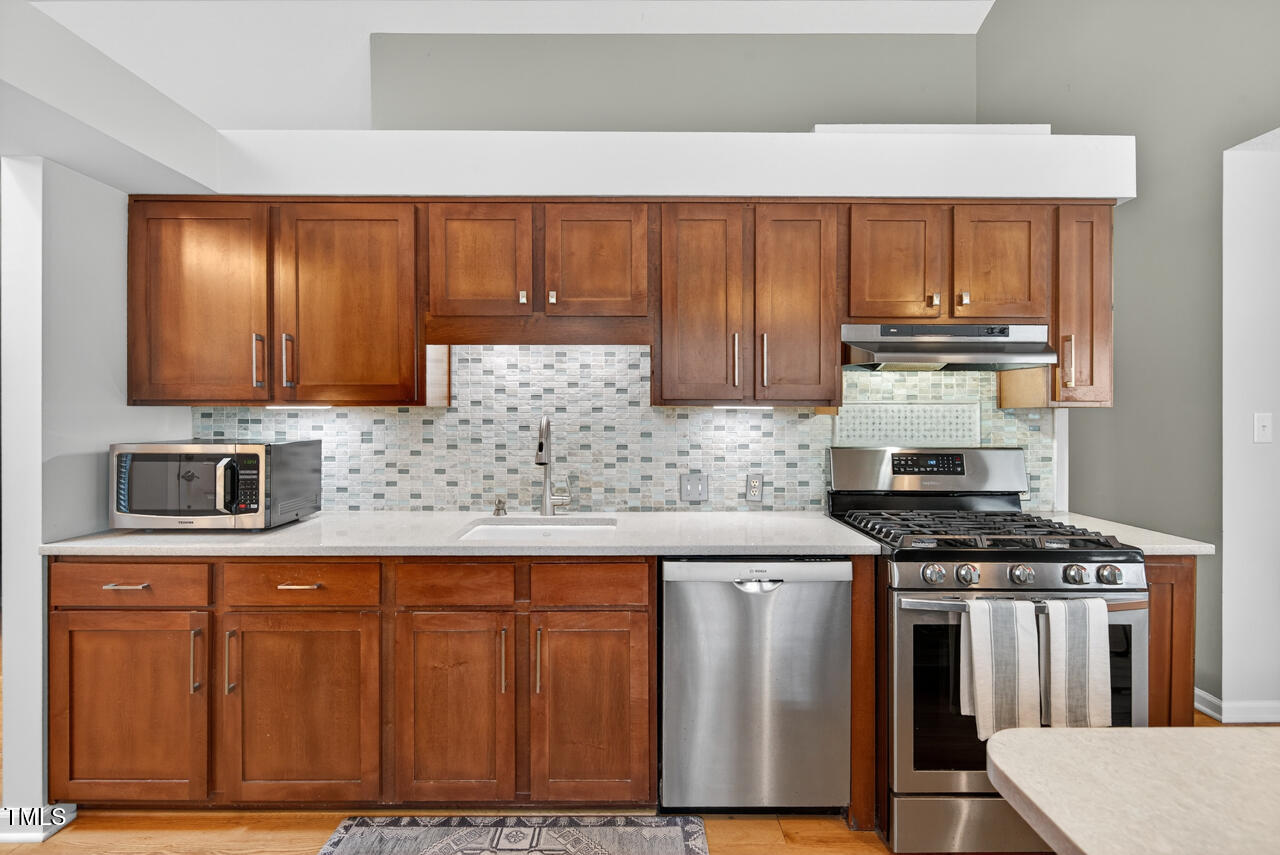 123 Weatherhill Point Carrboro, NC 27510 - Photo 13 of 25 a kitchen with stainless steel appliances granite countertop a stove a sink and a microwave