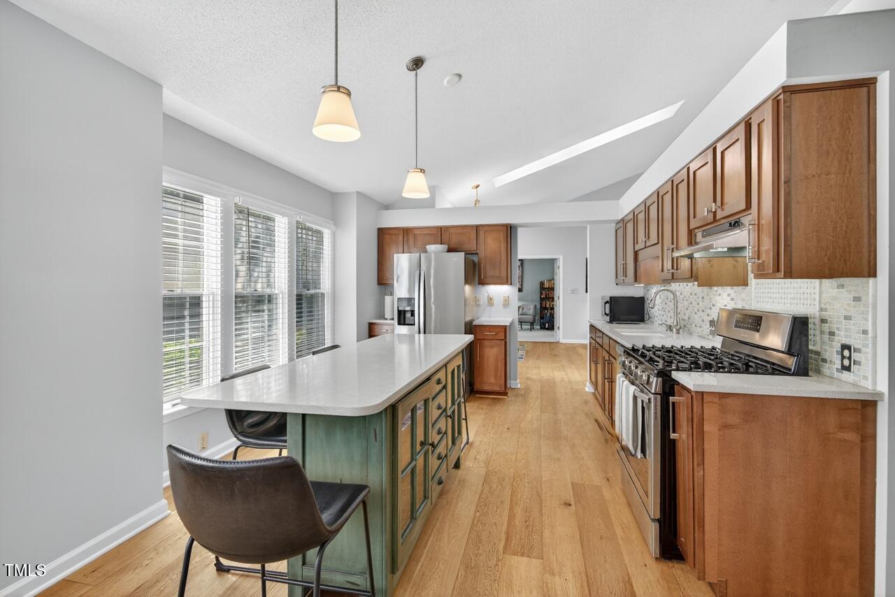 123 Weatherhill Point Carrboro, NC 27510 - Photo 16 of 25 a dining room with stainless steel appliances granite countertop a stove top oven a dining table and chairs with wooden floor