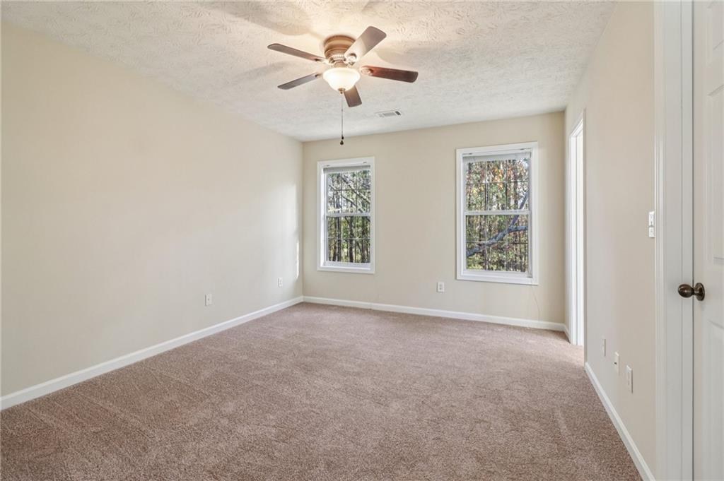 572 Casey's Crossing Winder, GA 30680 - Photo 11 of 31 an empty room with windows and a ceiling fan