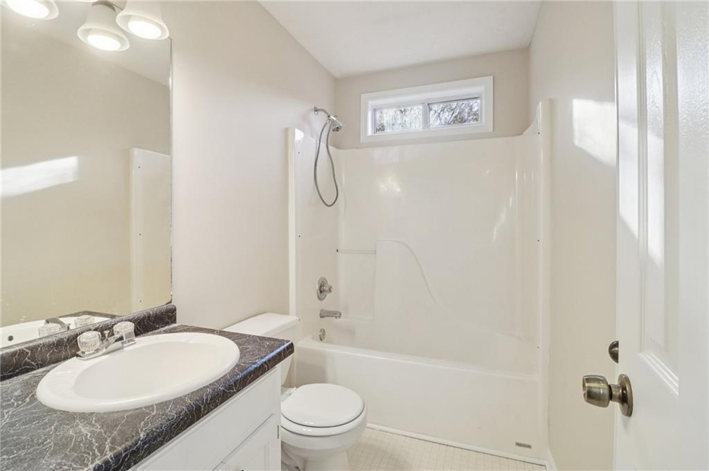 572 Casey's Crossing Winder, GA 30680 - Photo 19 of 31 a bathroom with a granite countertop sink toilet a mirror and shower