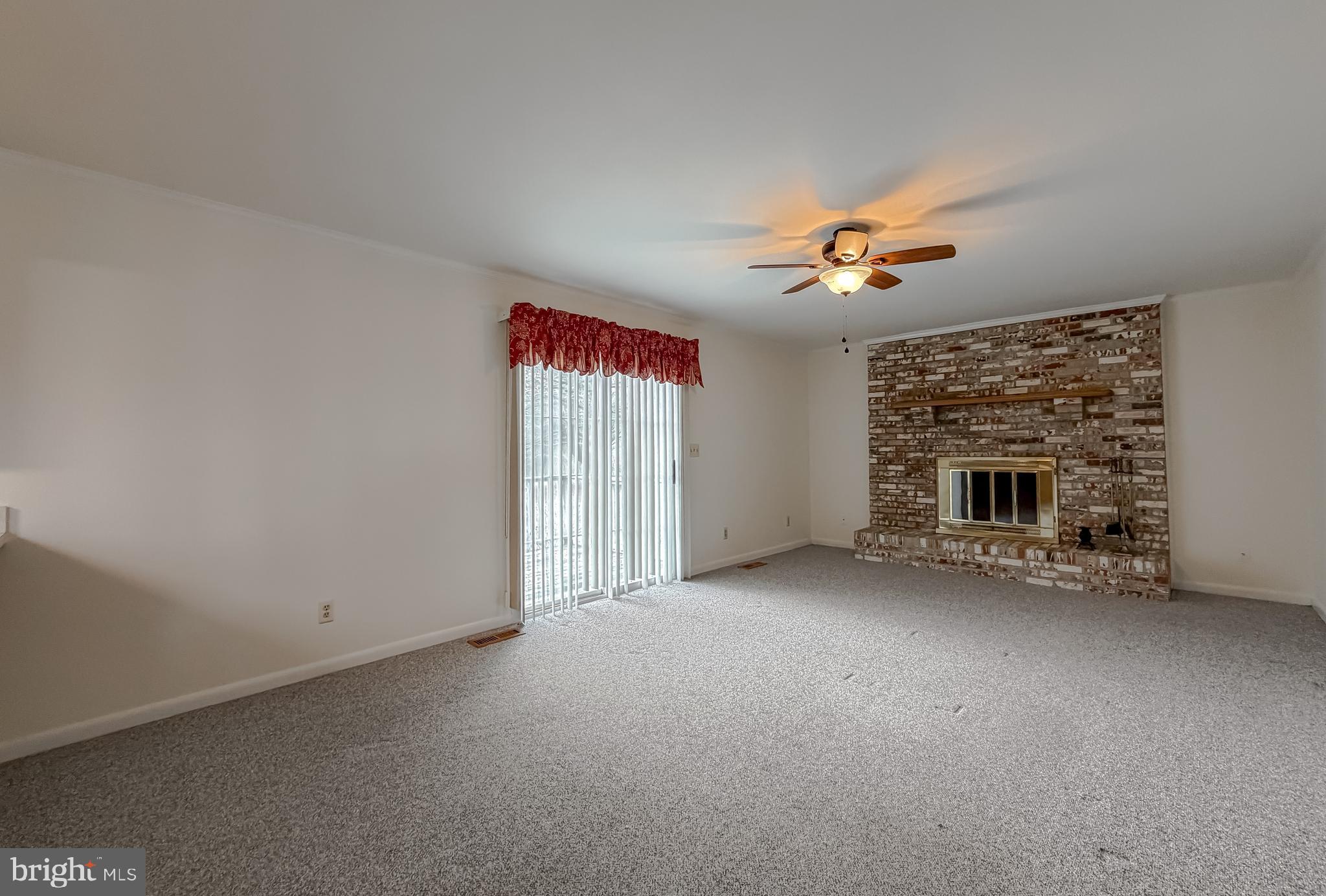 7615 Mill Creek Road Benedict, MD 20612 - Photo 11 of 37 an empty room with a fireplace and fan