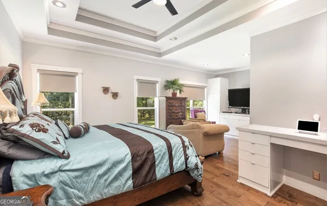 a bedroom with a bed a flat screen tv and a large window with the outer view