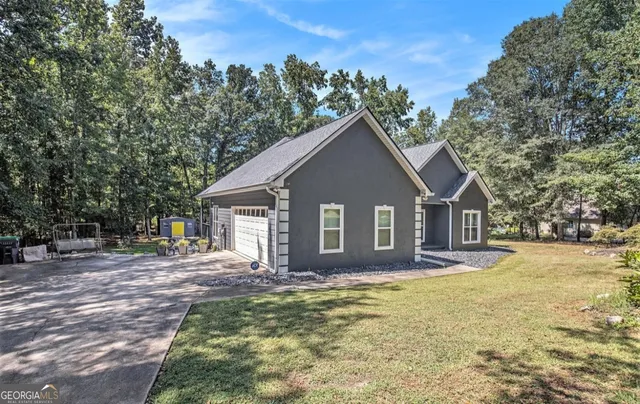 a front view of house with yard and trees in the background