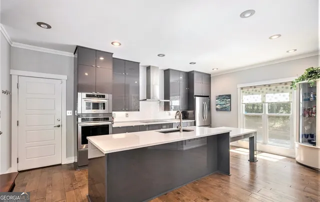a large kitchen with a counter space a sink appliances and cabinets