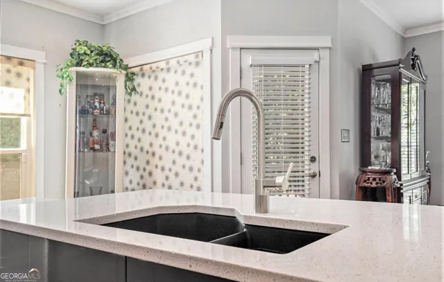 a kitchen with a sink a large window and stainless steel appliances
