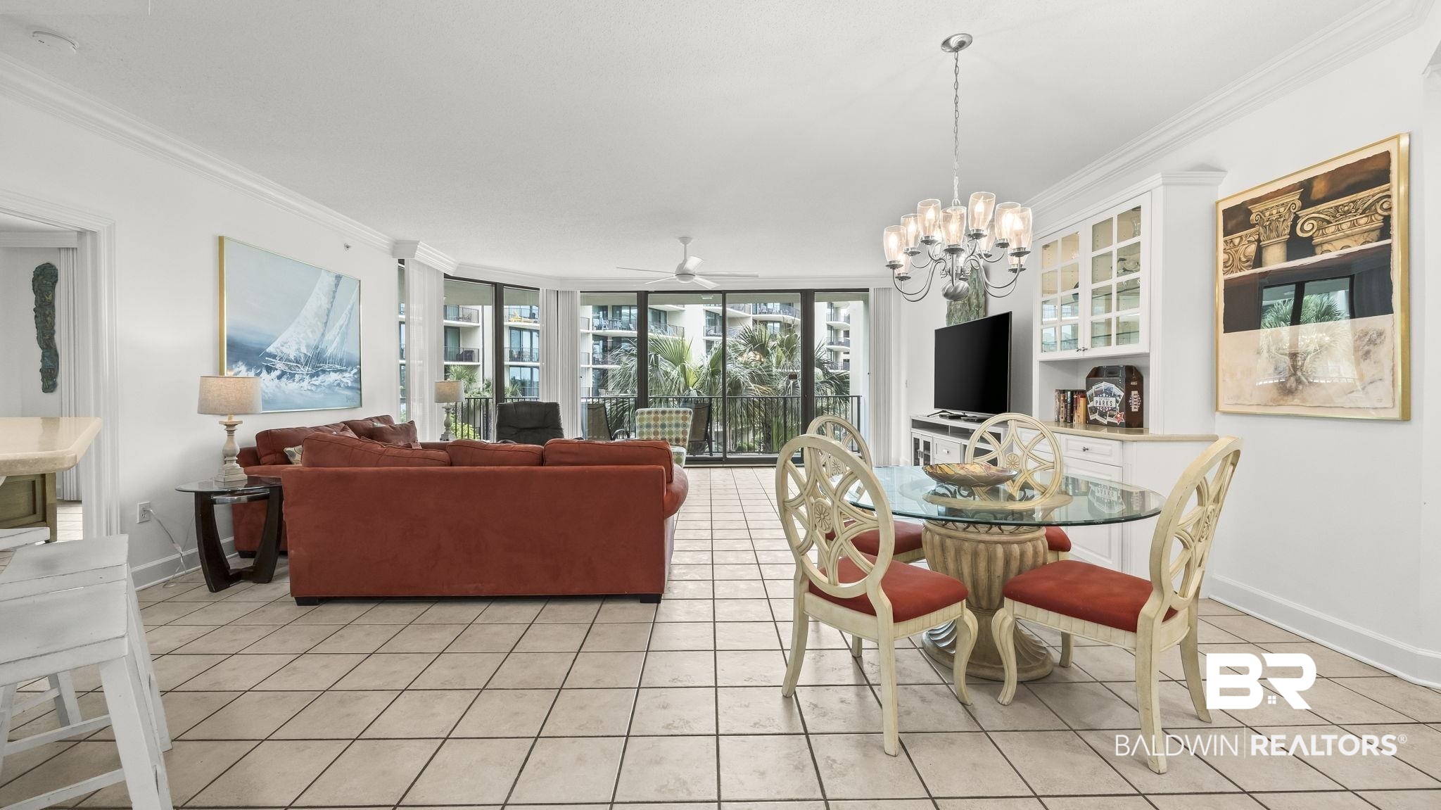 27580 Canal Road, Unit 1213 Orange Beach, AL 36561 - Photo 3 of 27 Open-concept living space with tile flooring, a built-in display cabinet, and a multi-pane glass door opening to an exterior balcony