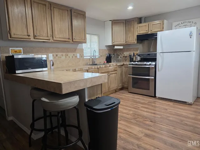 a kitchen with a refrigerator a stove a sink and a microwave