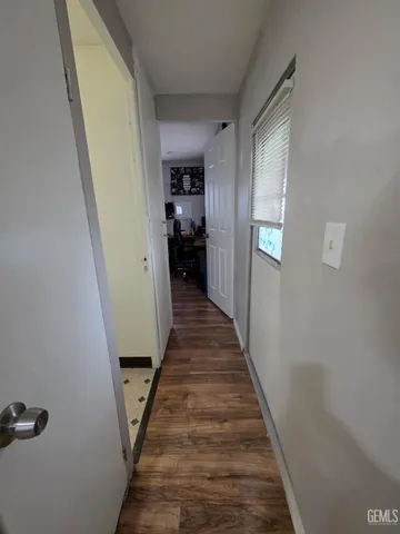 a view of a hallway with wooden floor and staircase