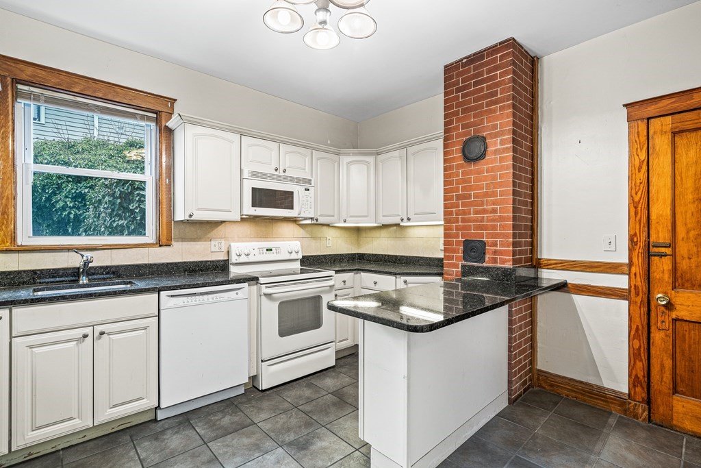 73 Halifax Street Boston, MA 02130 - Photo 12 of 18 a kitchen with granite countertop white cabinets and white appliances