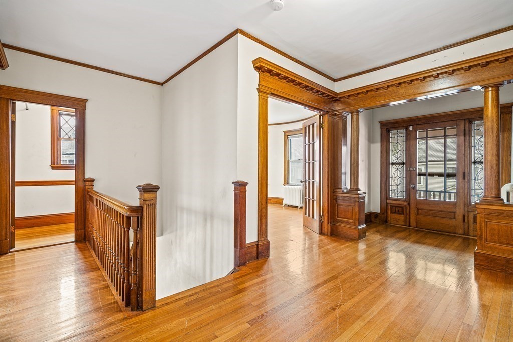 73 Halifax Street Boston, MA 02130 - Photo 3 of 18 a view of a hallway with wooden floor and furniture