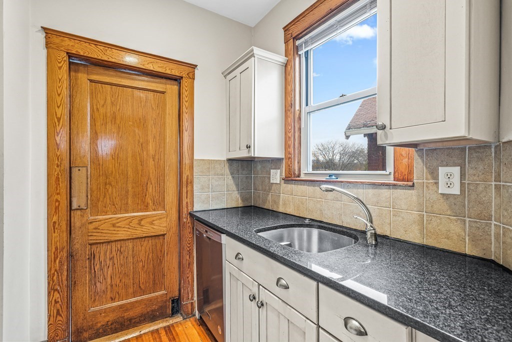 73 Halifax Street Boston, MA 02130 - Photo 6 of 18 a kitchen with granite countertop a sink and a refrigerator