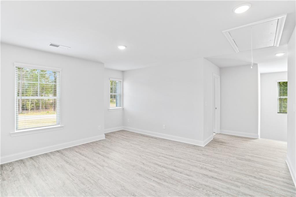 70 Cooper Drive Mansfield, GA 30055 - Photo 14 of 32 an empty room with wooden floor and windows