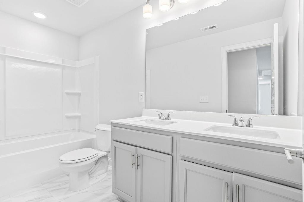 70 Cooper Drive Mansfield, GA 30055 - Photo 28 of 32 a bathroom with a toilet a sink a bathtub and a mirror