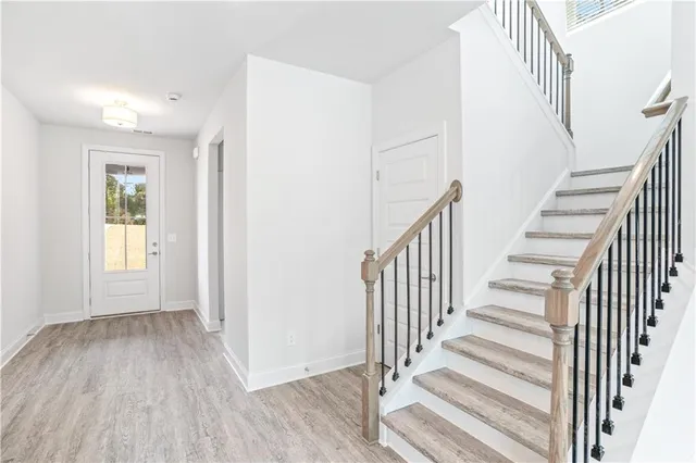 a view of a hallway with wooden floor and entryway