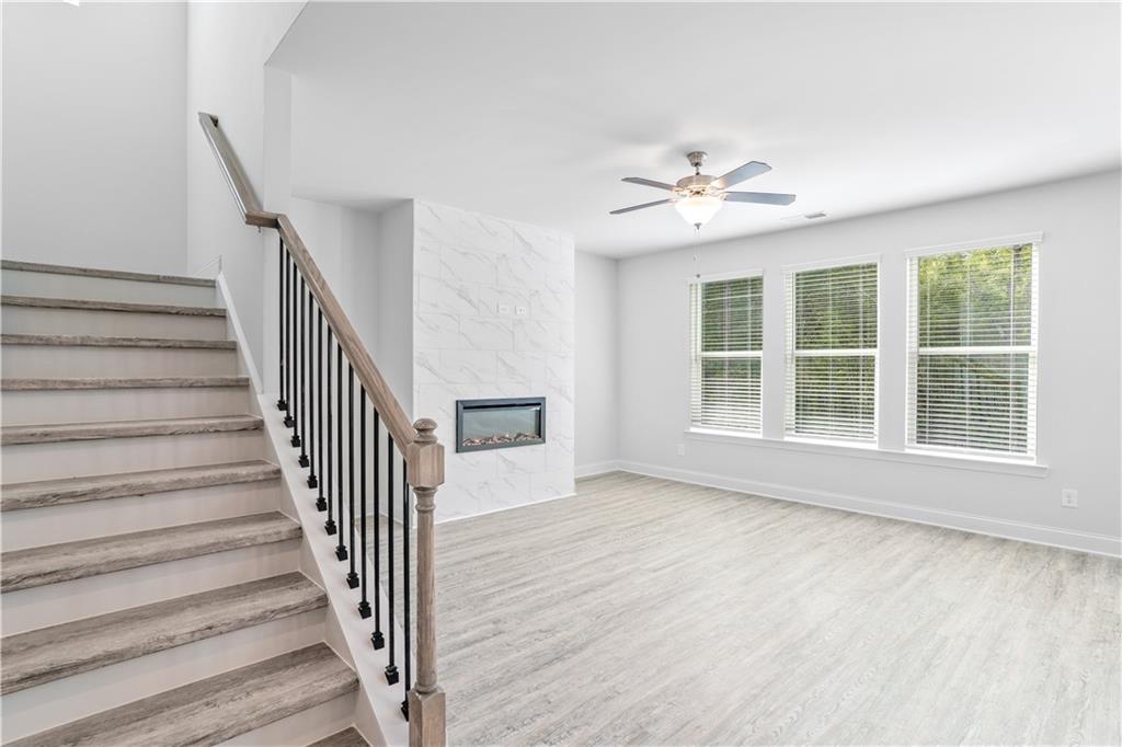 70 Cooper Drive Mansfield, GA 30055 - Photo 6 of 32 a view of an empty room with wooden floor and a ceiling fan