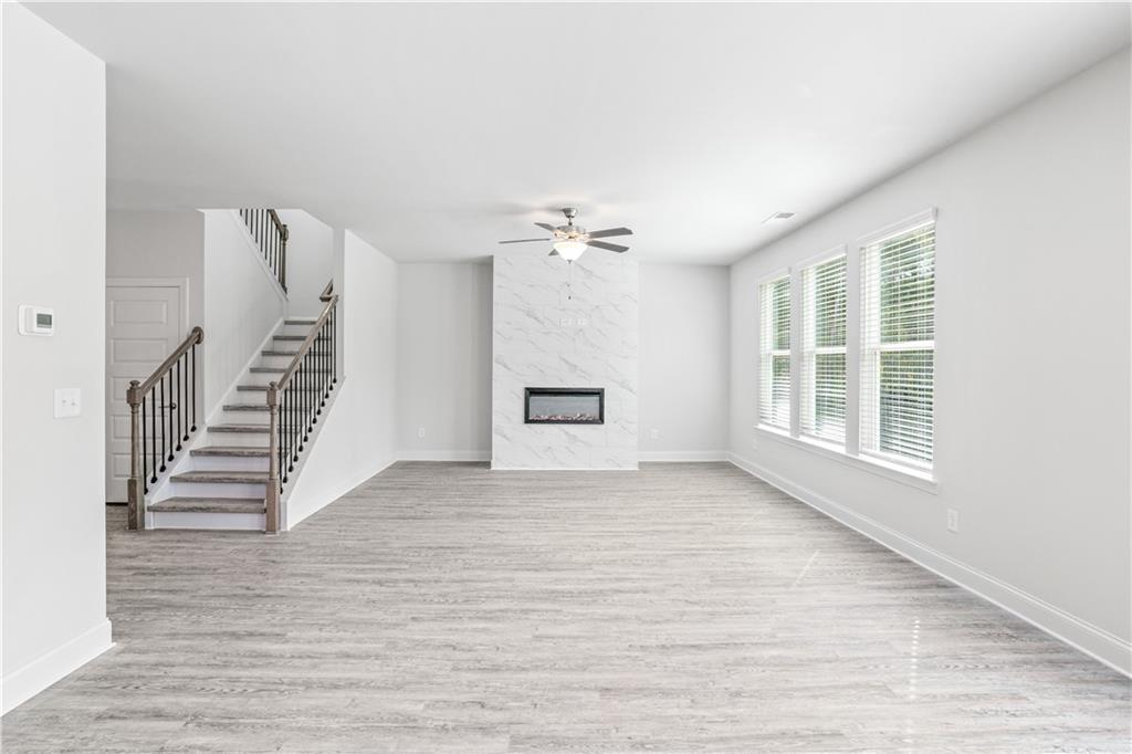 70 Cooper Drive Mansfield, GA 30055 - Photo 7 of 32 a view of an empty room with wooden floor and a window