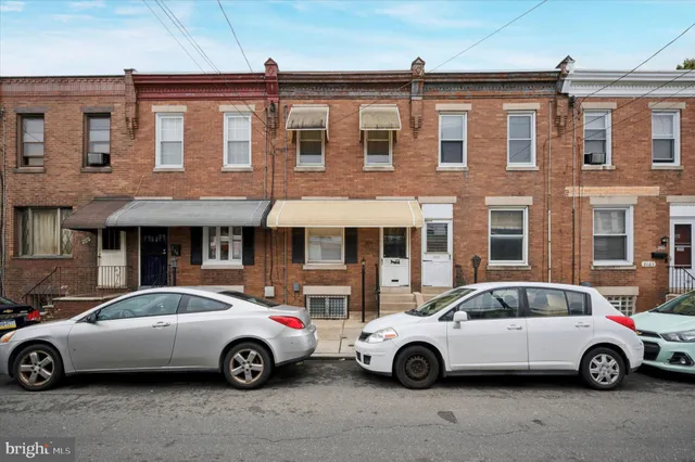 a car parked in front of a brick house