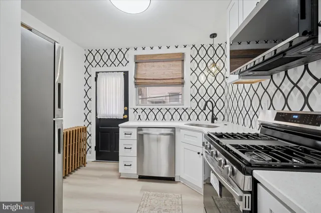 a kitchen with cabinets appliances and a stove