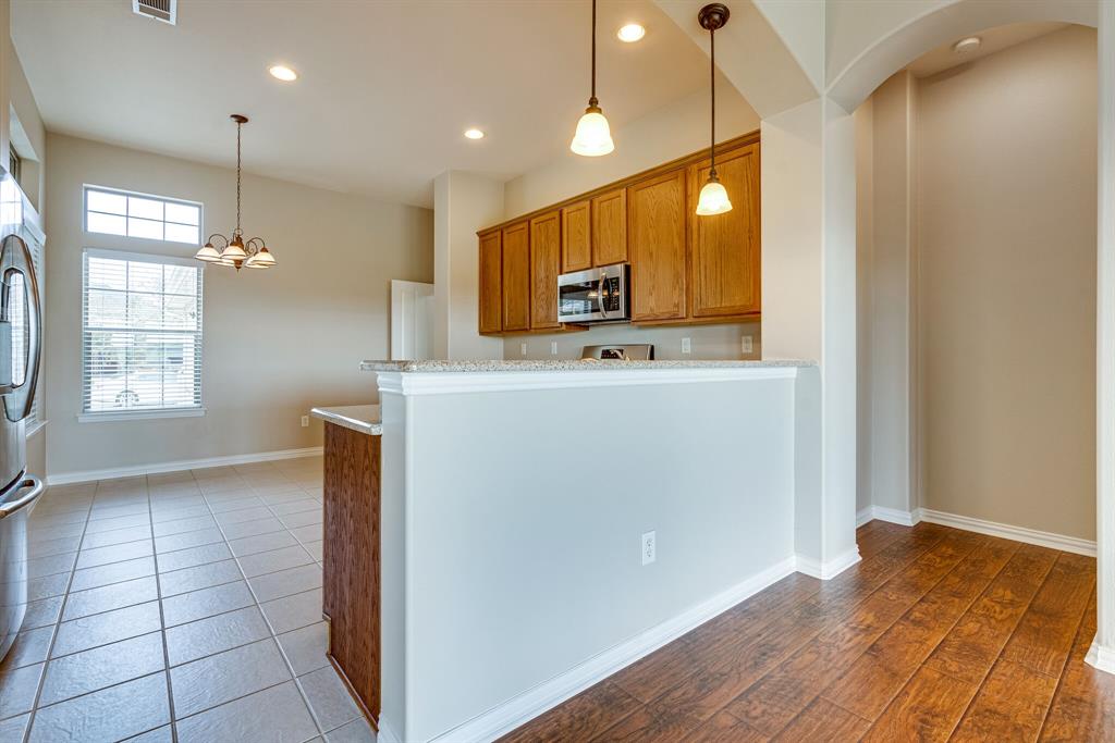 9109 Perimeter Street Denton, TX 76207 - Photo 13 of 27 Kitchen with decorative light fixtures, brown cabinets, stainless steel appliances, a peninsula, and recessed lighting