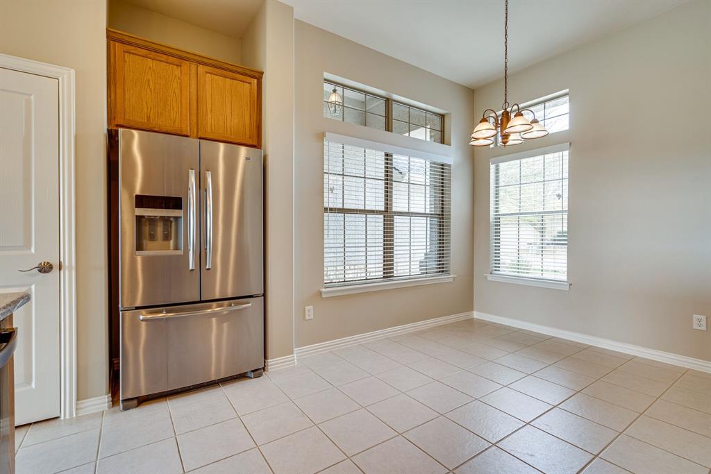 9109 Perimeter Street Denton, TX 76207 - Photo 15 of 27 Kitchen featuring stainless steel refrigerator with ice dispenser, light tile patterned floors, hanging light fixtures, and brown cabinetry